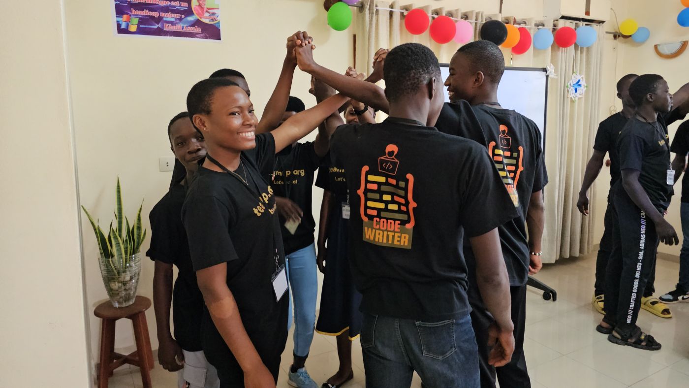 An instructor congratulates two students, hands raised